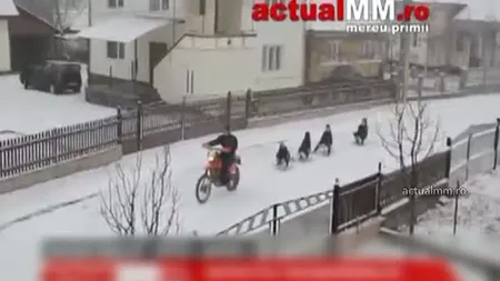 Distracţie nebună într-o localitate din Maramureş. Copii traşi cu sania de o motocicletă