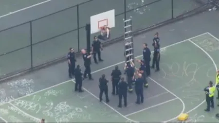 Scenă amuzantă sub panou. 17 poliţişti se chinuie să salveze un om dintr-un coş de baschet VIDEO