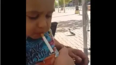 REVOLTĂTOR. Copil de 2 ani încurajat de tată să fumeze şi să bea VIDEO