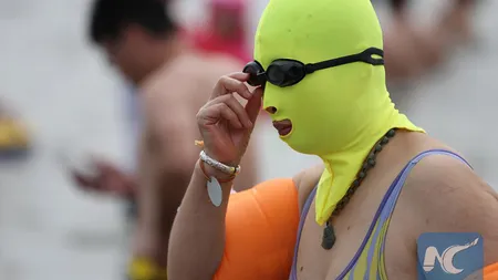 Modă bizară pe plajele din China. Oamenii poartă cagule de frica radiaţiilor VIDEO