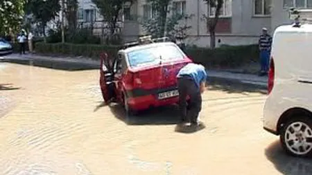 Stradă din Piteşti inundată după ce s-a spart o conductă de apă. O maşină a rămas blocată