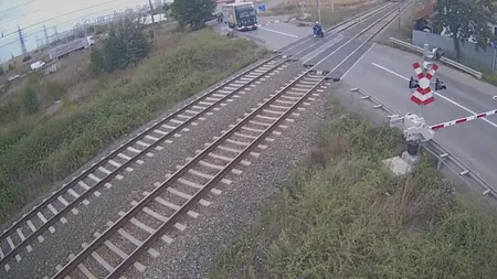 Un motociclist, filmat cum trece cu viteză prin faţa unui tren şi face un gest obscen către mecanic VIDEO