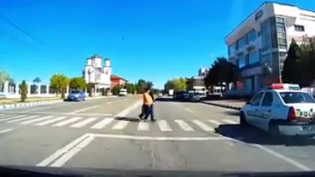Poliţişti încalcă legea. O maşină a Poliţiei, la un pas să spulbere 2 oameni chiar pe trecerea de pietoni VIDEO