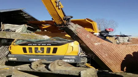 Şofer de basculantă, rănit grav după ce a acroşat o poartă de cărămidă care a căzut peste cabină