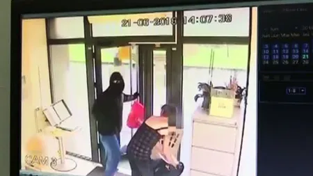 Primele imagini cu tentativa de jaf de la bancă. Reacţia halucinantă a unei femei când vede hoţul înarmat lângă ea VIDEO
