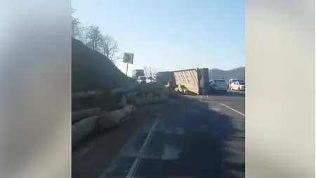 TIR cu lemne răsturnat, pe DN14. Buşteni din autotren au căzut pentru o maşină. 4 persoane sunt rănite
