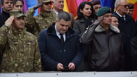 Ministrul Apărării, fotografiat când citea pe telefon în timp ce militarii întorşi din Afganistan îi dădeau onorul