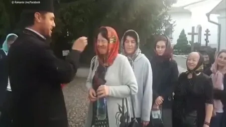 Credincioşi plesniţi peste ochi cu aghiasmă în curtea unei mănăstiri. Imaginile au devenit virale