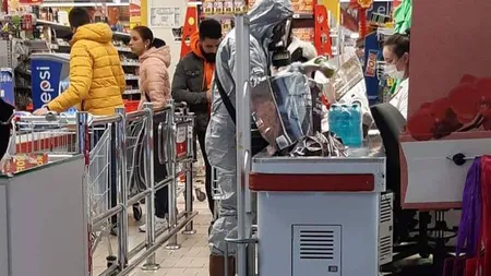 Imaginea zilei surprinsă într-un supermarket din România: S-a îmbrăcat în costum de protecţie pentru a merge la cumpărături