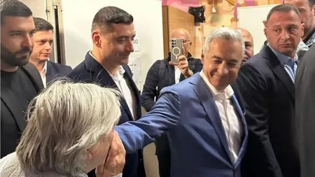 Călin Georgescu, așteptat ca Mesia la secția de votare. Românii s-au înghesuit să-i pupe mâna și să-i ofere flori VIDEO