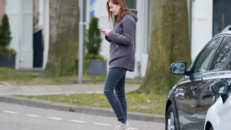 Cod rutier 2026. Țara în care plătești 100 de euro amendă dacă stai cu ochii în telefon atunci când traversezi strada