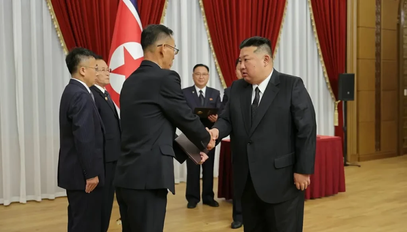 Liderul nord-coreean Kim Jong-un dă mâna cu un cercetător în domeniul apărării în timpul unei ceremonii în onoarea oamenilor de știință și a oficialilor cărora li se atribuie progresele în tehnologia militară, pe 29 august, în această fotografie distribuită de Rodong Sinmun.