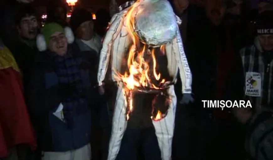 O păpuşă reprezentându-l pe Traian Băsescu, incendiată de mai mulţi protestatari la Timişoara VIDEO