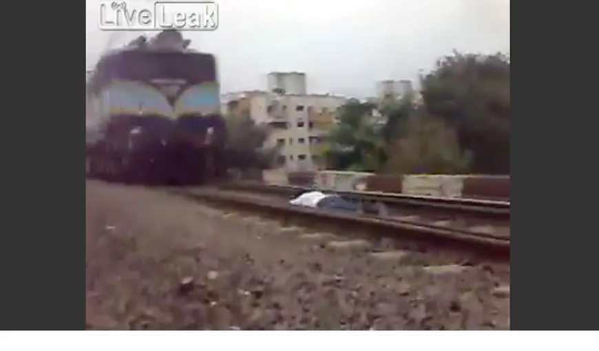 Inconştienţă: Un indian se întinde între şine pentru ca trenurile să treacă peste el VIDEO