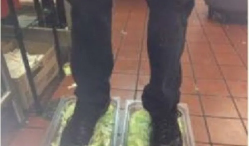 ŞOCANT: Un angajat al Burger King s-a fotografiat cu picioarele în salată şi a pus poza pe Internet