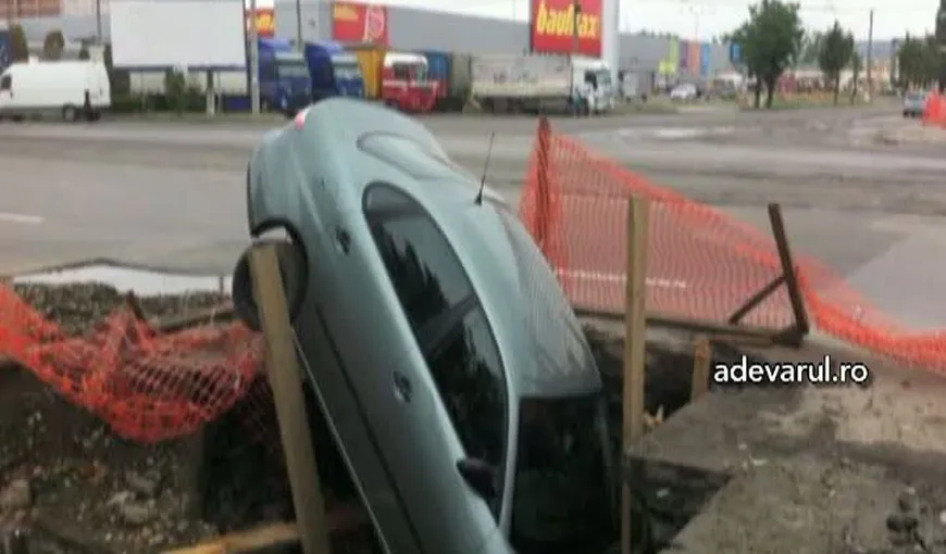 Maşină înghiţită de groapa din asfalt VIDEO