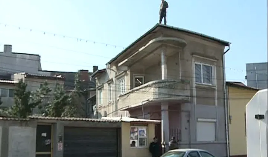 Evacuare cu scandal. Un bărbat s-a urcat pe acoperişul casei şi a ameninţat că îşi dă foc VIDEO