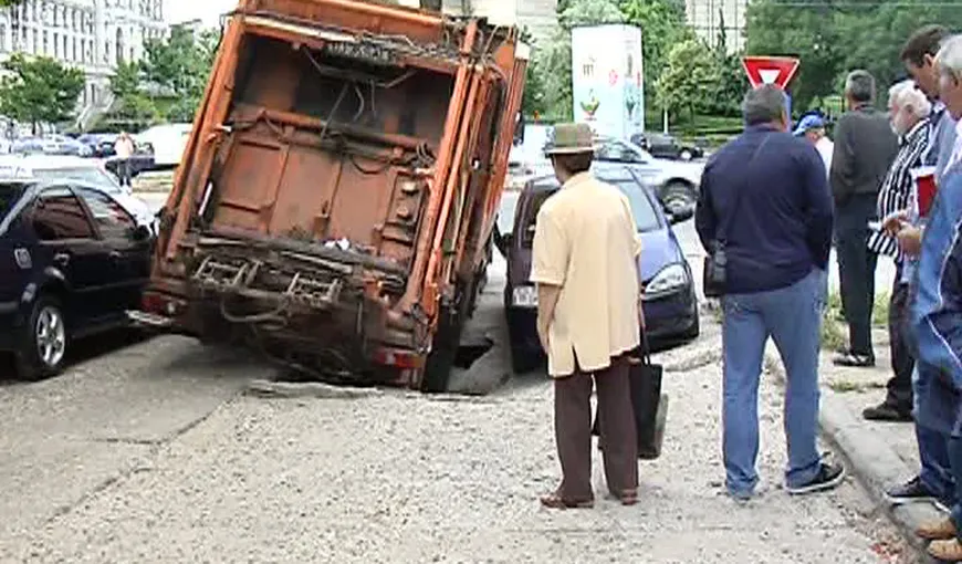 O maşină de gunoi, înghiţită de asfalt, în Craiova VIDEO