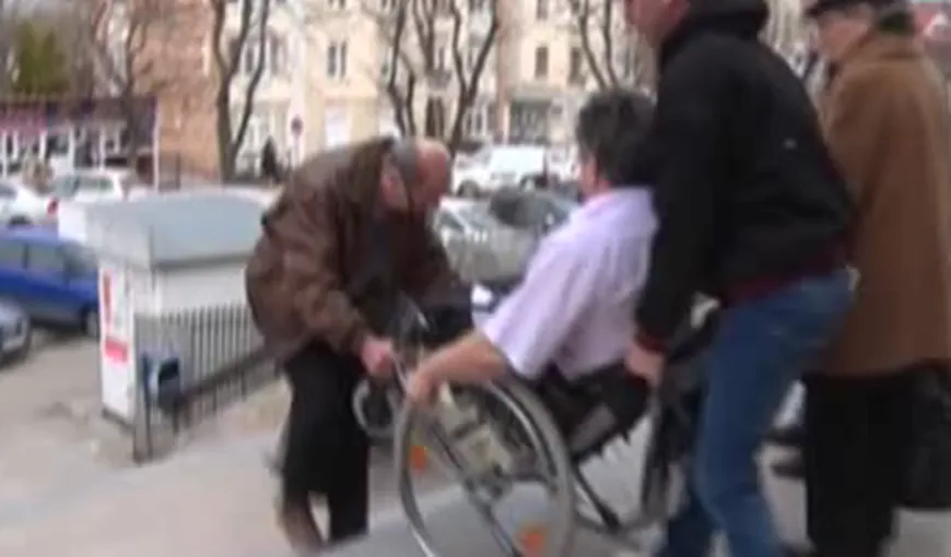 REVOLTĂTOR. Bărbat cu handicap, purtat pe braţe în faţa instanţei VIDEO