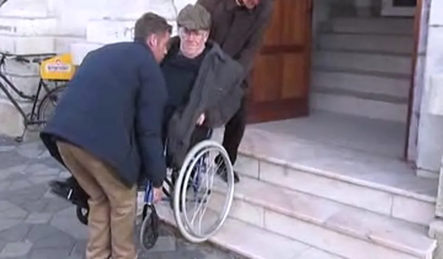 REVOLTĂTOR. Un bătrân în scaun cu rotile, ajutat de trecători să intre în Tribunalul Bacău VIDEO