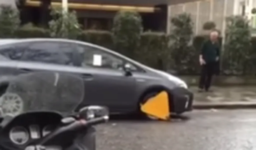 Un bărbat îşi distruge maşina încercând să plece după ce roata i-a fost blocată VIDEO