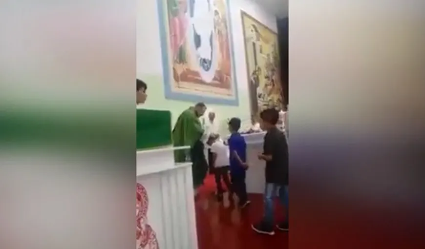 Metoda barbară de a binecuvânta. Un preot este filmat în timp ce loveşte copiii în faţa altarului