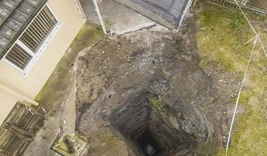 O gaură uriaşă a „înghiţit” curtea unei case. Ce au descoperit localnicii când au filmat înăuntru cu o dronă VIDEO