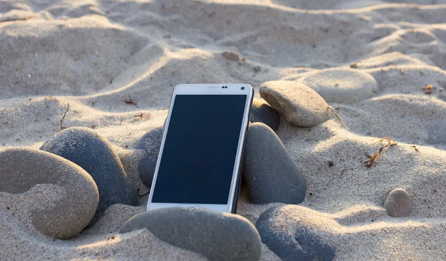 Telefonul mobil se poate strica la mare. Iată cum îl protejezi de nisip, apă, soare şi vânt