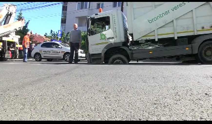 Maşină de gunoi, înghiţită de asfalt VIDEO