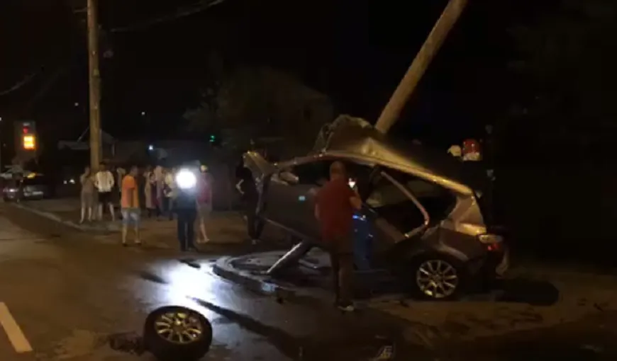 Accident spectaculos la Piteşti – o maşină a rămas suspendată pe un stâlp de electricitate. VIDEO