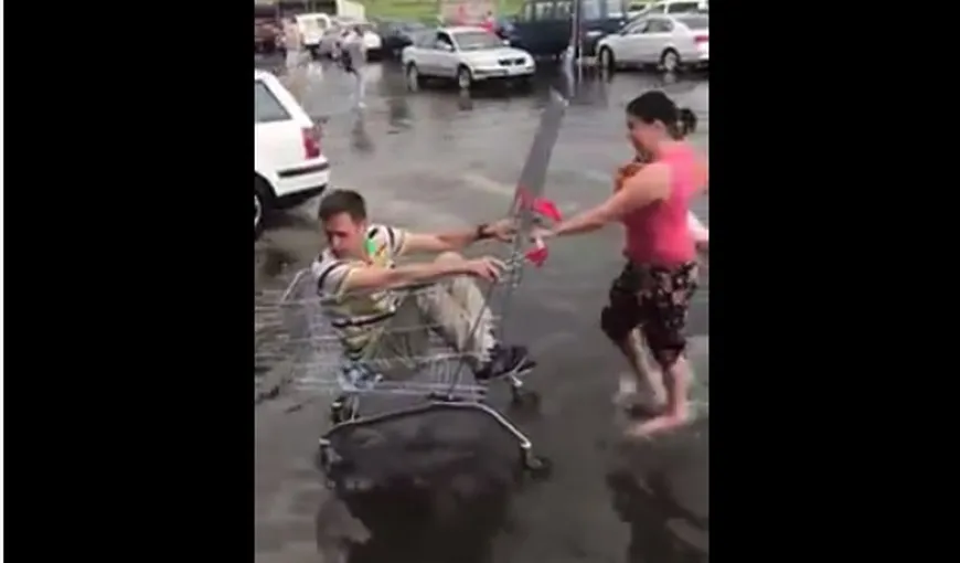 Soţul în căruţ, soţia cu copilul în braţe prin apă VIDEO