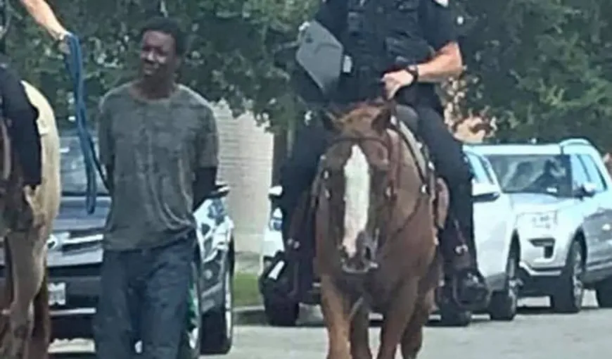 Umilinţă fără margini. Un bărbat de culoare, legat cu sfoară la gât şi „tras” de un poliţist pe cal: suntem în 2019, nu în 1819