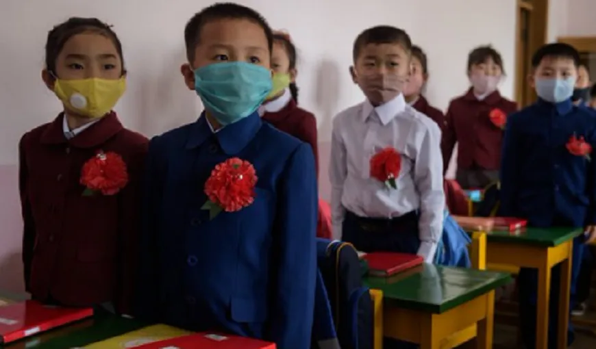 Elevii nord-coreeni s-au reîntors la şcoală. Cu flori roşii în piept şi măşti de protecţie, au fost aşezaţi în bănci unii lângă alţii
